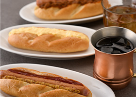 ホットドッグ、たまごドッグ、ホットチリドッグと飲み物が並ぶ机の上