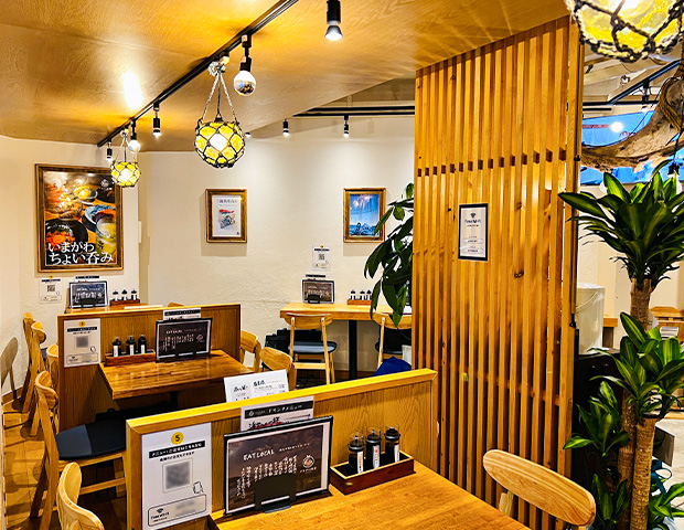 港町をイメージした、木の温もり溢れる店内にテーブル席が並ぶ