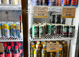 缶コーヒーやペットボトルのお茶が陳列された冷蔵庫